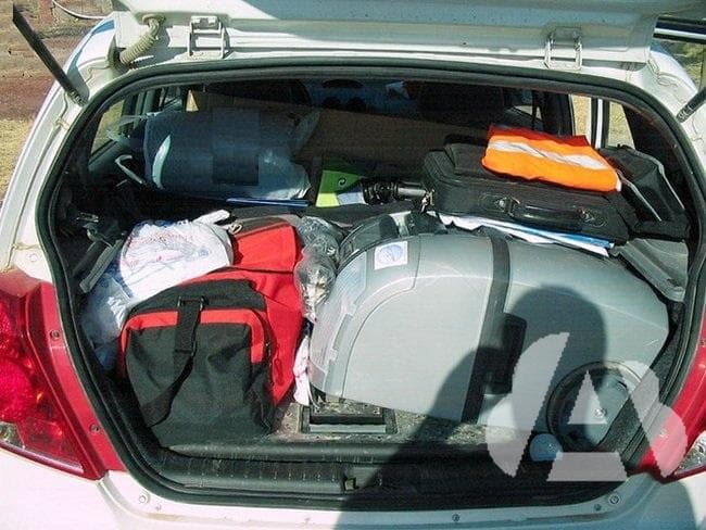 ¿Cómo debe colocarse la carga que se transporta en un vehículo?