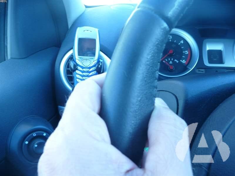 Hablar por un teléfono con dispositivo de manos libres durante la conducción...