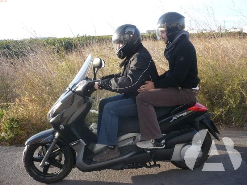 El conductor de una motocicleta, que lleva una persona en el asiento trasero...